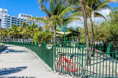 a red bike parked next to a green fence at Welworth condo units Miami Beach in Miami Beach
