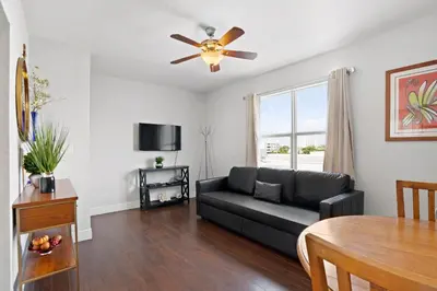 a living room with a couch and a ceiling fan at Welworth condo units Miami Beach in Miami Beach