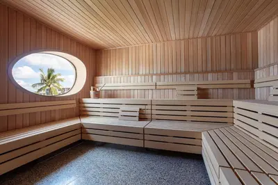 a sauna with wooden paneling and a circular window at The Standard Spa, Miami Beach in Miami Beach