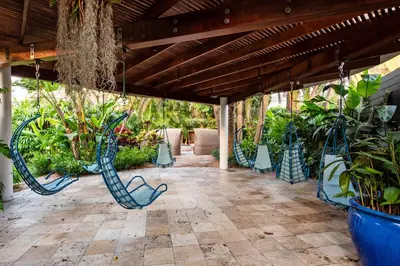 a patio with blue metal chairs and plants at The Standard Spa, Miami Beach in Miami Beach
