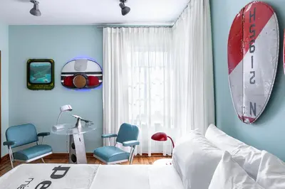 a bedroom with a bed and a surfboard on the wall at Pelican Hotel in Miami Beach