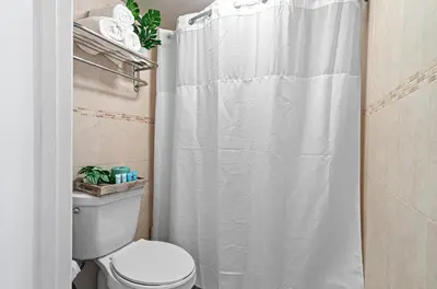a bathroom with a white shower curtain and a toilet at Hotolos Hollywood in Hollywood