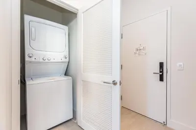 a laundry room with a washer and dryer next to a door at Espectacular Condo Esquina Beach House Hollywood Apartamento in Hollywood