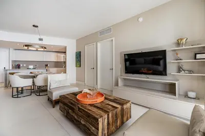 a living room with a tv and a table in a room at Amazing views on the 29th floor 2BR Beach Resort in Hallandale Beach