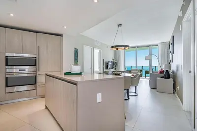 a kitchen and living room with a view of the ocean at Amazing views on the 29th floor 2BR Beach Resort in Hallandale Beach