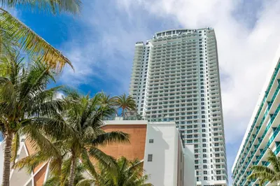 a tall white building with palm trees in front of it at Relaxing Getaway with Intracoastal Views in Hollywood