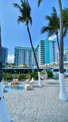 a beach with chairs and palm trees and buildings at Seacoast by Miami Ambassadors in Miami Beach