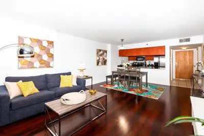 a living room with a blue couch and a kitchen at Star Stay Miami Yellow Brickell in Miami