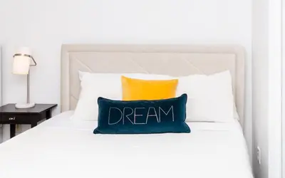 a pillow with dream written on it sitting on a bed at Star Stay Miami Yellow Brickell in Miami