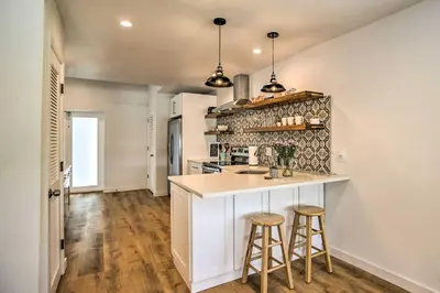 a kitchen with a counter and two stools at Modern Home with Shared Pool in Fort Lauderdale! in Fort Lauderdale