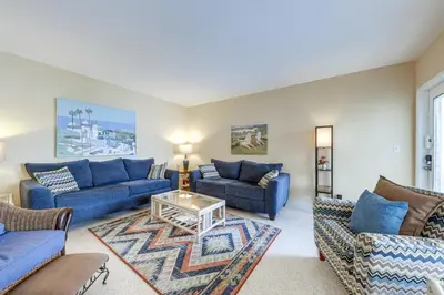 a living room with blue couches and a table at Ft Lauderdale Apt with Pool - 1 Mi to Beach Access! in Fort Lauderdale