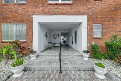 a courtyard of a brick building with a white door at Ft Lauderdale Apt with Pool - 1 Mi to Beach Access! in Fort Lauderdale