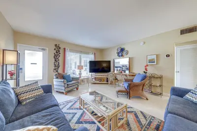 a living room with blue couches and a tv at Ft Lauderdale Apt with Pool - 1 Mi to Beach Access! in Fort Lauderdale