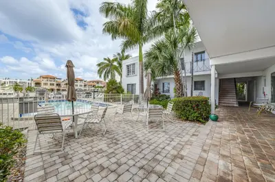a patio with a table and chairs and a pool at Ft Lauderdale Apt with Pool - 1 Mi to Beach Access! in Fort Lauderdale
