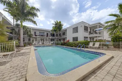 a swimming pool in front of a building at Ft Lauderdale Apt with Pool - 1 Mi to Beach Access! in Fort Lauderdale