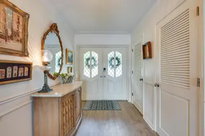 a hallway with white walls and a door with a mirror at Waterfront Fort Lauderdale House with Heated Pool! in Fort Lauderdale