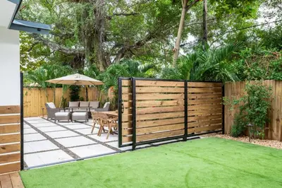 a garden with a wooden fence and a table with an umbrella at Casa Madeira @ the heart of Miami Design District in Miami