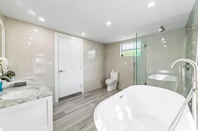 a bathroom with a tub and a sink and a toilet at Lakeside Vacation Home in Davie