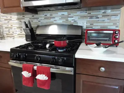 a kitchen with a black stove with red oven mittens at Family, Couples Retreat near Airport, Cruise Port & Beaches in Fort Lauderdale