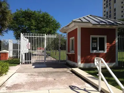 a white fence next to a small house at Gorgeous Beachy Chic Condo in Key Biscayne in Miami
