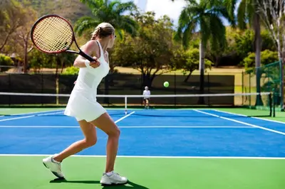 a woman holding a tennis racket on a tennis court at Gorgeous Beachy Chic Condo in Key Biscayne in Miami