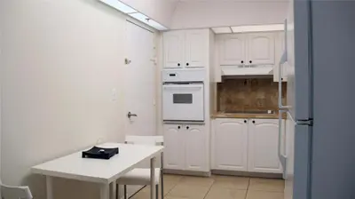 a kitchen with white cabinets and a white table at Miami HOLLYWOOD in Hollywood