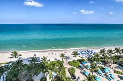 an aerial view of a beach with palm trees and the ocean at Beachfront Condo with Pool Access in Hollywood! in Hollywood