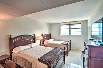 a bedroom with two beds and a television in it at Beachfront Condo with Pool Access in Hollywood! in Hollywood