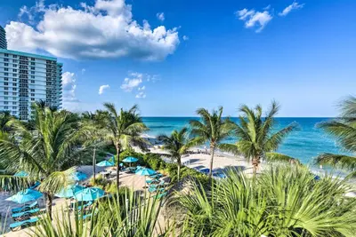 a view of a beach with palm trees and the ocean at Beachfront Condo with Pool Access in Hollywood! in Hollywood