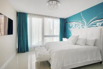 a bedroom with a white bed and a blue wall at NEW!!! W Brickell Miami- ICON DELUXE LOUNGE with 2 masters in Miami