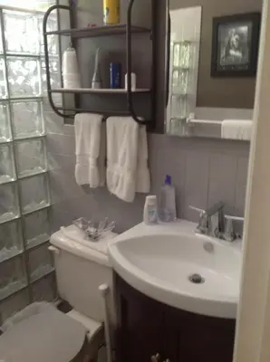 a bathroom with a sink and a toilet and towels at Coral Reef Guesthouse in Fort Lauderdale