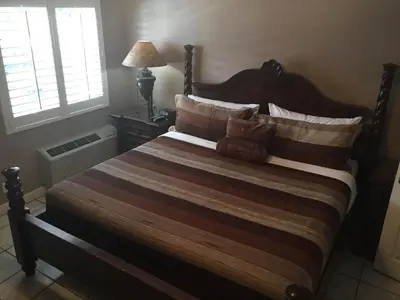 a bedroom with a large bed with pillows at Coral Reef Guesthouse in Fort Lauderdale