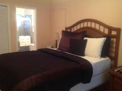 a bedroom with a large bed with many pillows at Coral Reef Guesthouse in Fort Lauderdale