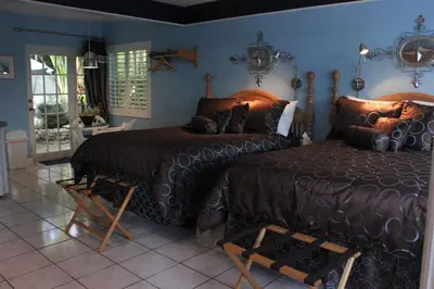 a bedroom with two beds in a room with blue walls at Coral Reef Guesthouse in Fort Lauderdale