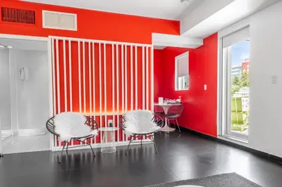 a room with two chairs and a red wall at Blanc Kara- Adults Only in Miami Beach