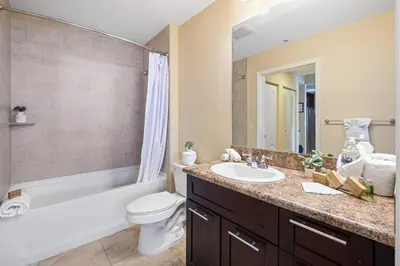 a bathroom with a sink and a toilet and a tub at Dharma Home Suites South Miami at Red Road Commons in Miami