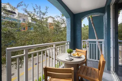 a patio with a table and chairs on a balcony at Dharma Home Suites South Miami at Red Road Commons in Miami