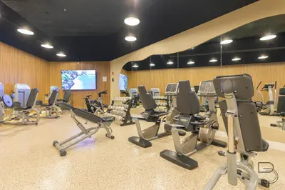 a gym with a bunch of chairs and a screen at Girasole Apartments in Miami Beach