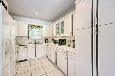 a kitchen with white cabinets and a refrigerator at Home with Pool in Upscale Pinecrest Village in Miami