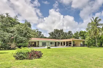 a house with a green lawn in front of it at Home with Pool in Upscale Pinecrest Village in Miami