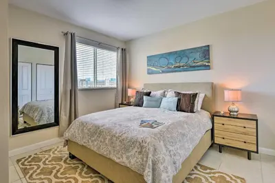 a bedroom with a large bed and a mirror at Miami Apartment by Coral Gables - Great Location! in Miami