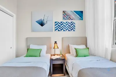 two beds in a white room with green pillows at Luxury Amenities, Infinity Pool, Gym, Hot Tub in Hollywood