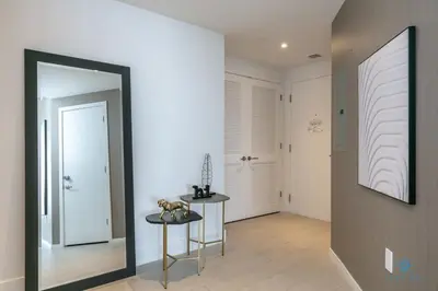 a hallway with a mirror and a table and a door at Corner Balcony - Enjoy 360 Views- Near Beach- Pool in Hollywood