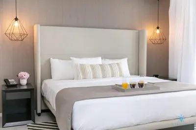 a bedroom with a large white bed with two drinks on it at Corner Balcony - Enjoy 360 Views- Near Beach- Pool in Hollywood