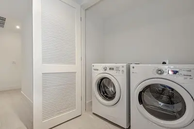 a white laundry room with a washer and dryer at Corner Balcony - Enjoy 360 Views- Near Beach- Pool in Hollywood