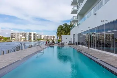 a swimming pool next to a building with a body of water at Hyde Beach House Luxury Condo-Resort 2808 condo in Hollywood Beach