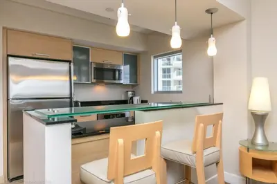 a kitchen with a bar and two chairs at 2 BR Luxury Suite in Marenas Beach Resort 2508 condo in Miami Beach