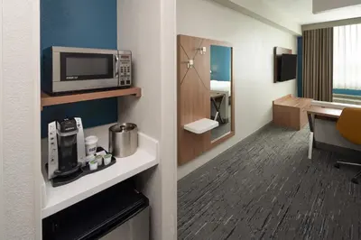 a hotel room with a microwave and a kitchen at Holiday Inn Express Miami Airport-Blue Lagoon Area by IHG in Miami