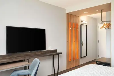 a bedroom with a flat screen tv on a wall at Tru By Hilton Ft Lauderdale Airport in Dania Beach