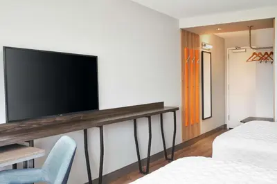 a room with a flat screen tv on a wall at Tru By Hilton Ft Lauderdale Airport in Dania Beach